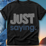 Black t-shirt with "JUST saying." in large grey and blue text.