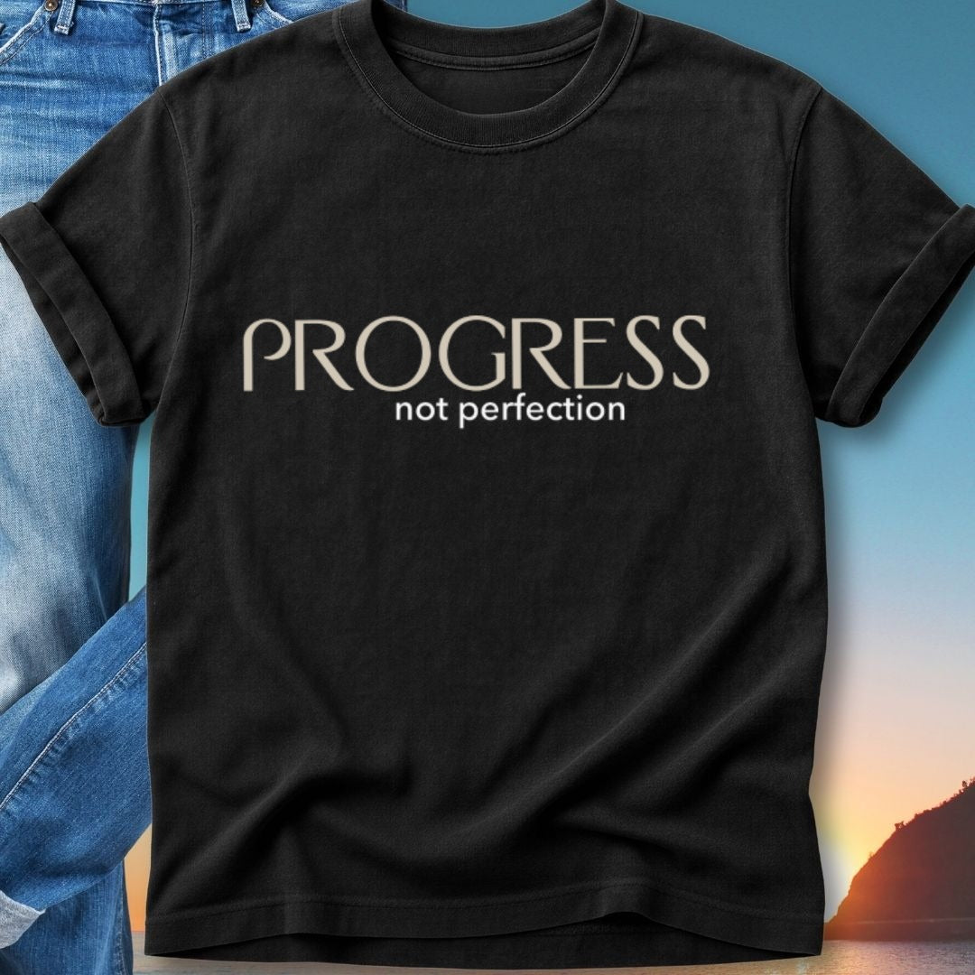Black t-shirt with white text "PROGRESS not perfection" over a sunset.