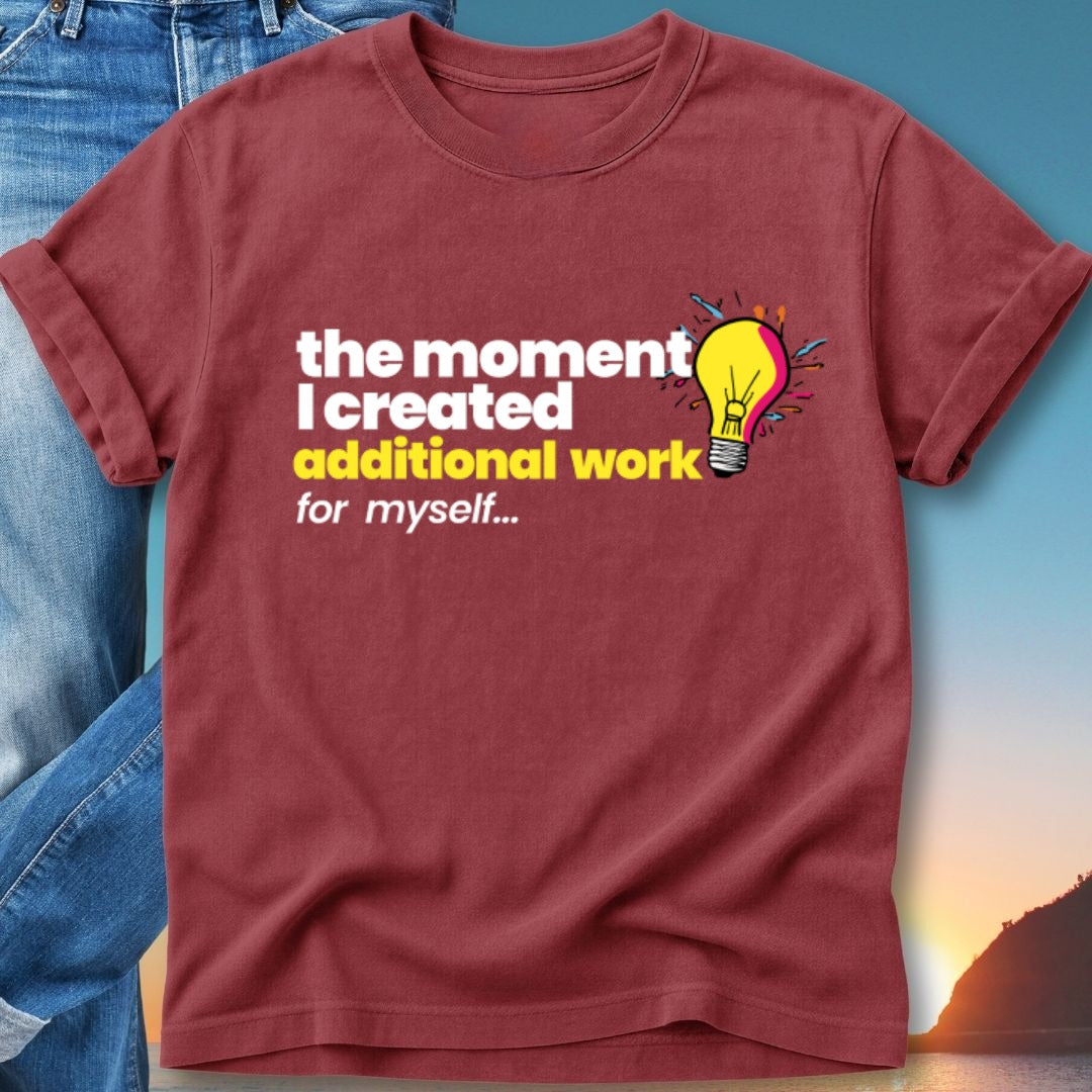 T-shirt with text "the moment I created additional work for myself" and a lightbulb icon.