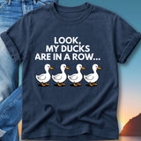 Navy t-shirt with four white cartoon ducks and text "Look, my ducks are in a row..."